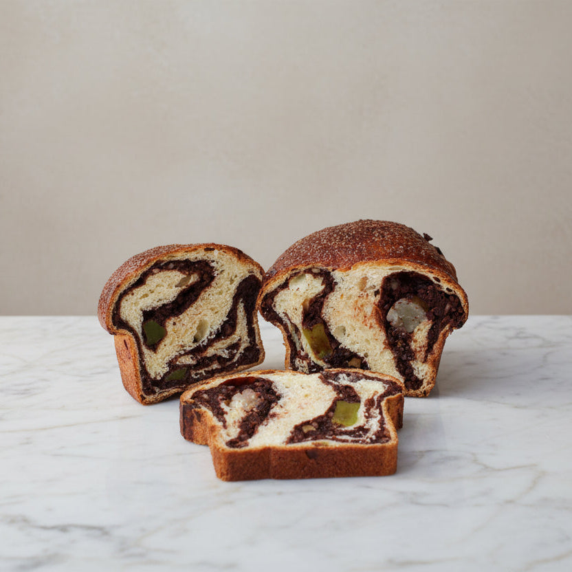 Traditional Romanian Cozonac sweet bread with a cocoa, orange zest and Turkish Delight filling, sliced to reveal its marbled interior