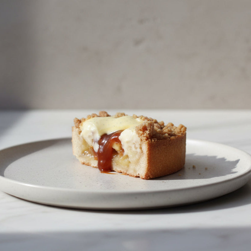 Apple crumble tart with golden shortbread crust, vanilla cream and caramel drizzle