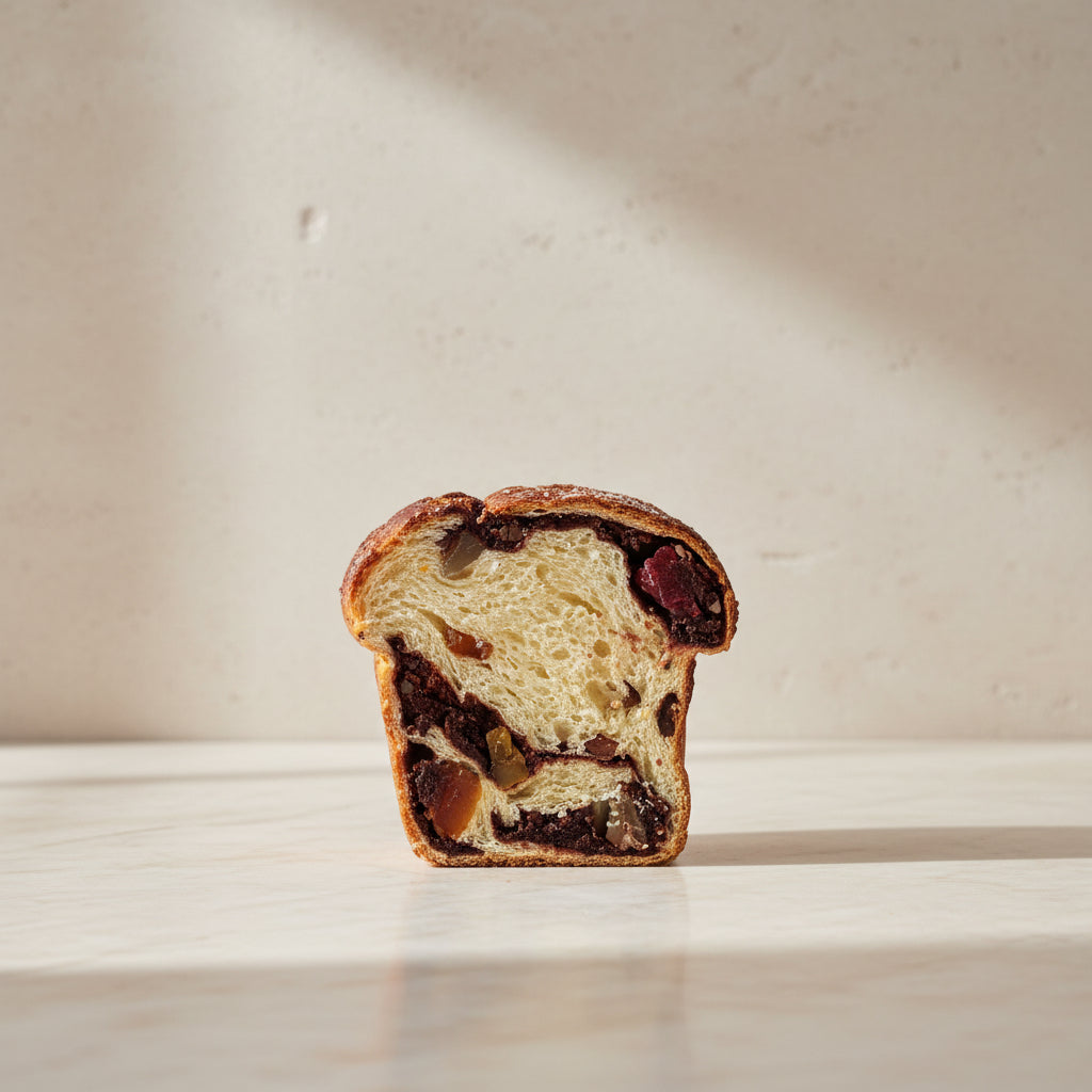Traditional Romanian Cozonac sweet bread with a cocoa, orange zest and Turkish Delight filling, sliced to reveal its marbled interior