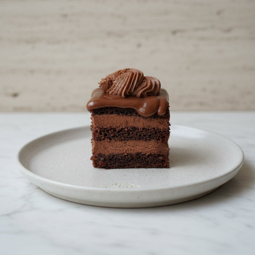 Amandina Romanian chocolate cake slice with rum syrup and chocolate fondant handmade in London