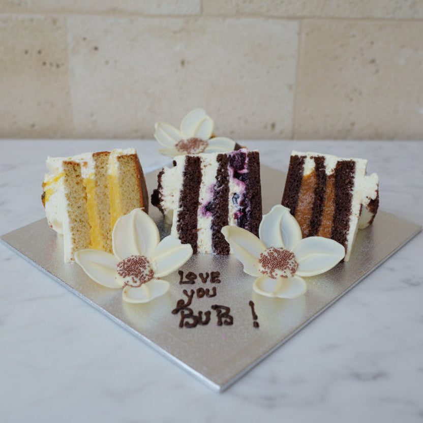 Slices of cake with decorative flowers and 'Love you Bub!' text on a wooden surface
