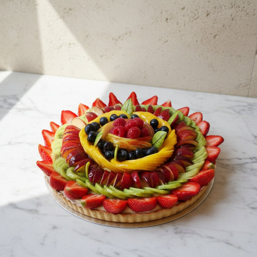 Large Italian fruit tart decorated with berries and citrus slices