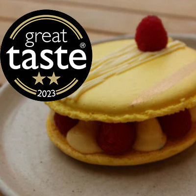 Award-winning passion fruit and raspberry giant macaron with gold leaf, fresh raspberries, and white chocolate mousse, handmade in North London