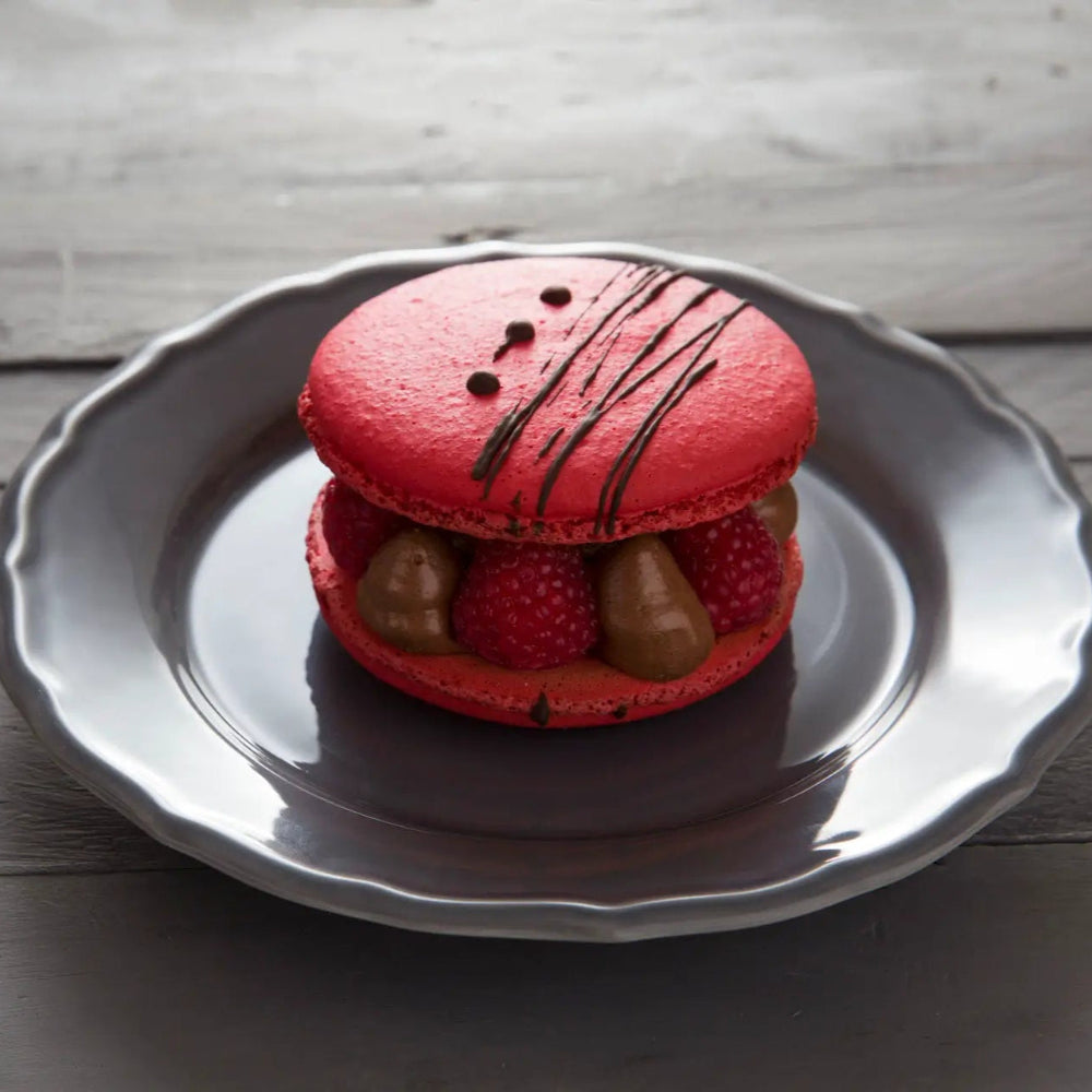 Giant chocolate macaron filled with Belgian chocolate mousse and fresh raspberries, with a crisp almond shell and chewy centre, handmade in North London