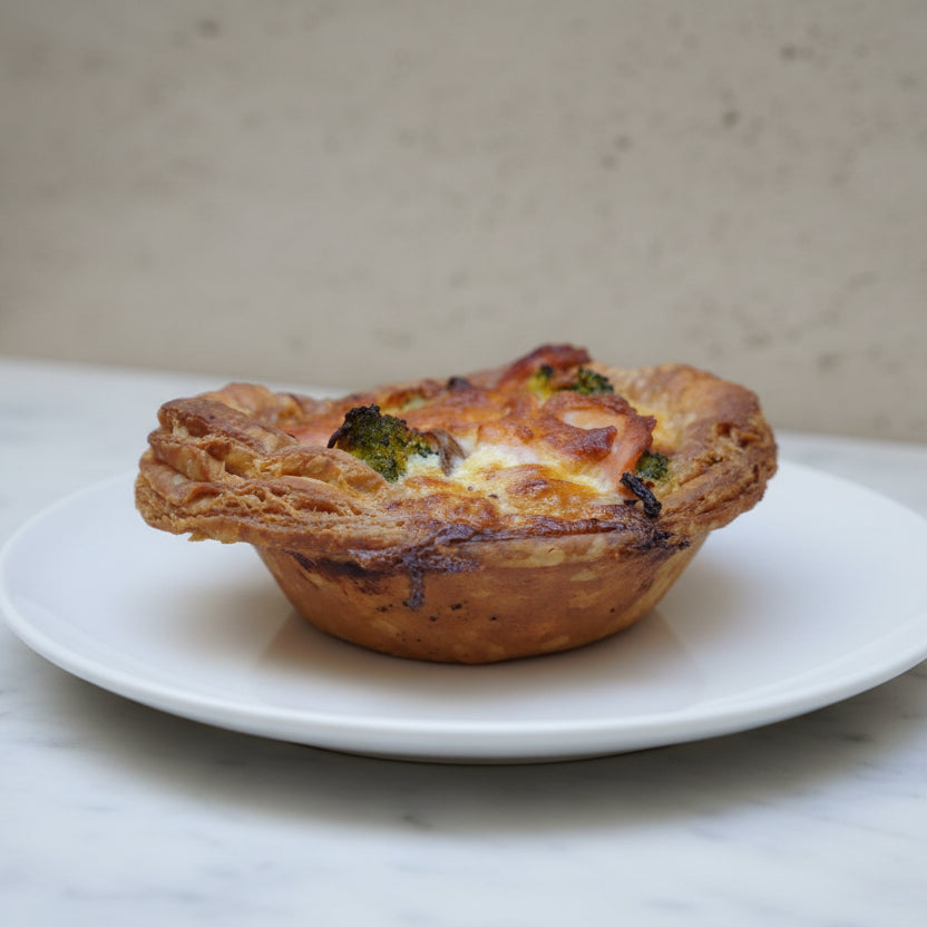 Golden shortcrust salmon and broccoli quiches with creamy filling, handmade in North London bakery and served in sets of four