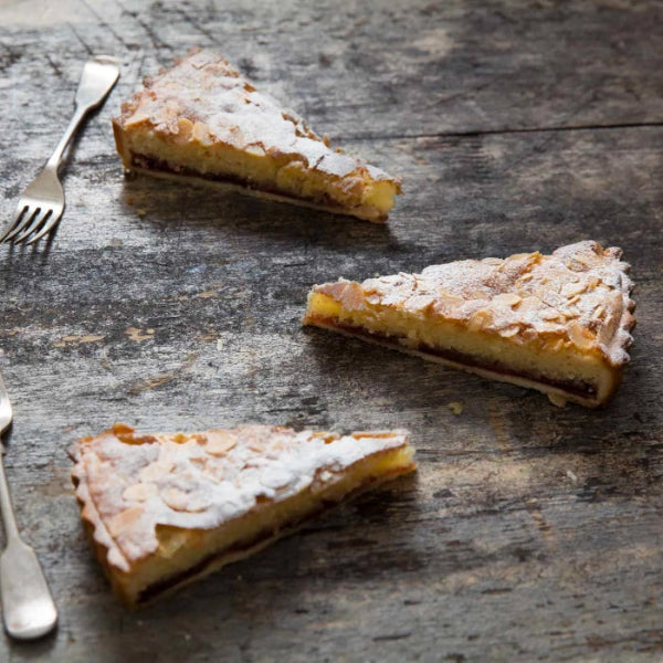 Strawberry Bakewell Tart slice with golden frangipane and sweet pastry base