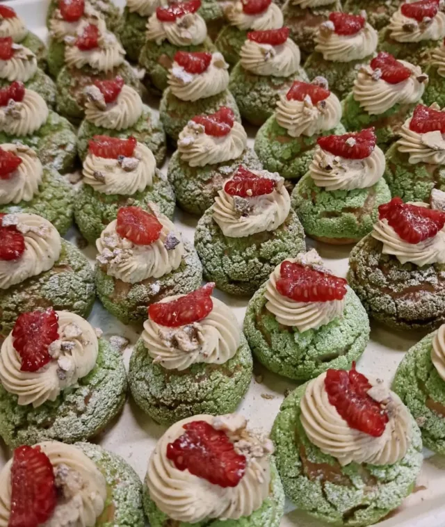 Say hi to our Pistachio Choux au Craquelin canapés.  Most of you know choux - a light, hollow pastry dough base used for traditional cream puffs and eclairs. It rises purely from steam during baking.  Many don't know craquelin though. This is a thin disc of sweet cookie dough (made from butter, sugar, and flour) placed on top of the pastry before baking. As the puff expands, this layer cracks, creating a beautifully uniform, crunchy outer shell.  We've got pistachio as our star flavour profile. The hollow centre is filled generously with velvety pistachio cream, with a fresh raspberry on top for balance.  These were made bespoke for a wedding event. Drop us a line if you want some!